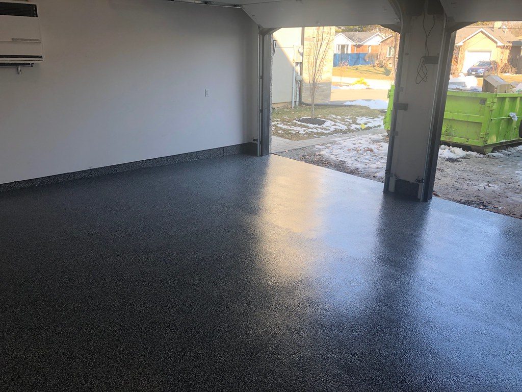 Dark charcoal flake epoxy garage floor looking out to the driveway in Sioux Falls